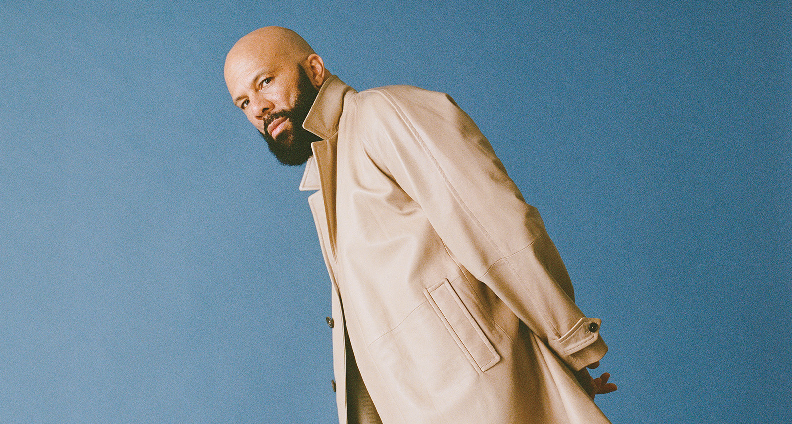 Common leans in front of blue background.