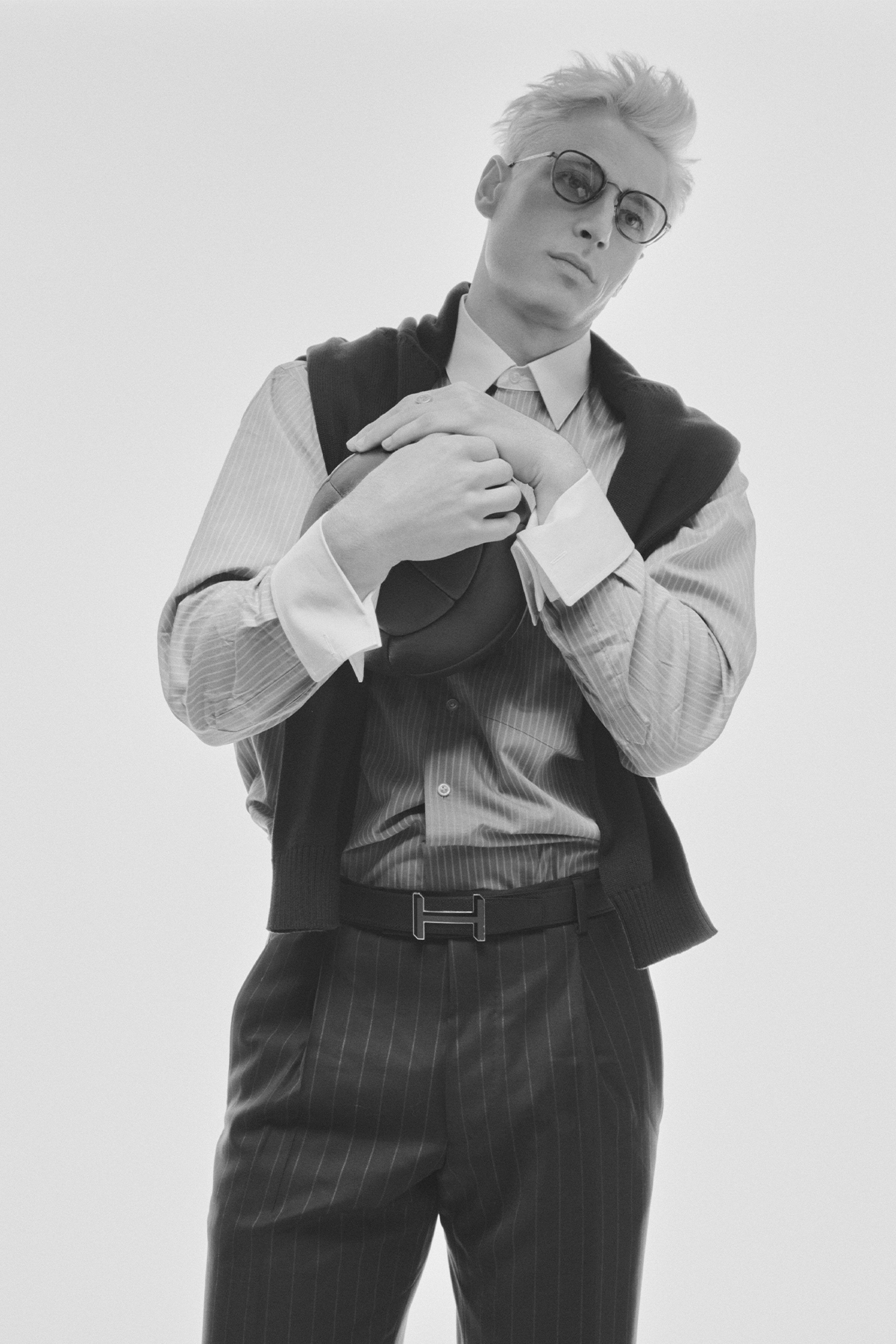 Male model in black and white, with black vest and white button up with Hermes belt