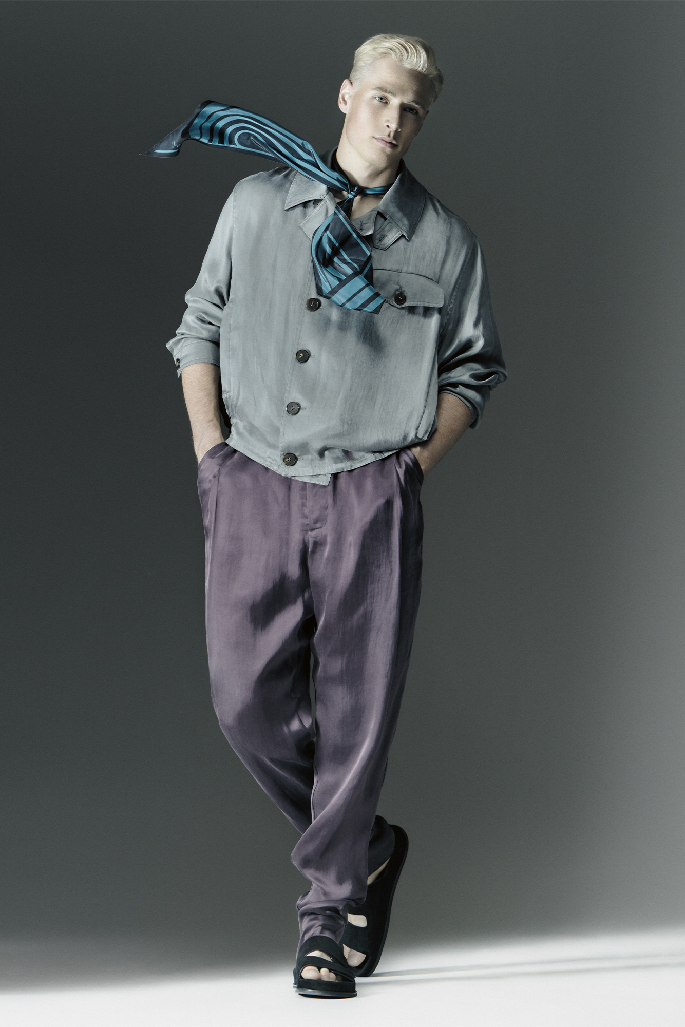 Male model in silk shirt and purple silk pants with hand in pocket